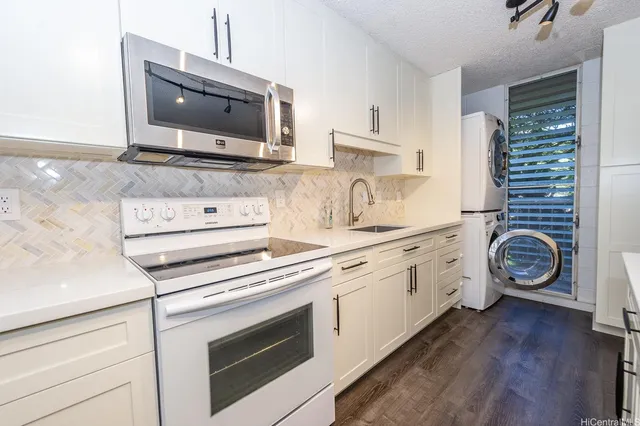 a kitchen with granite countertop a stove and a microwave