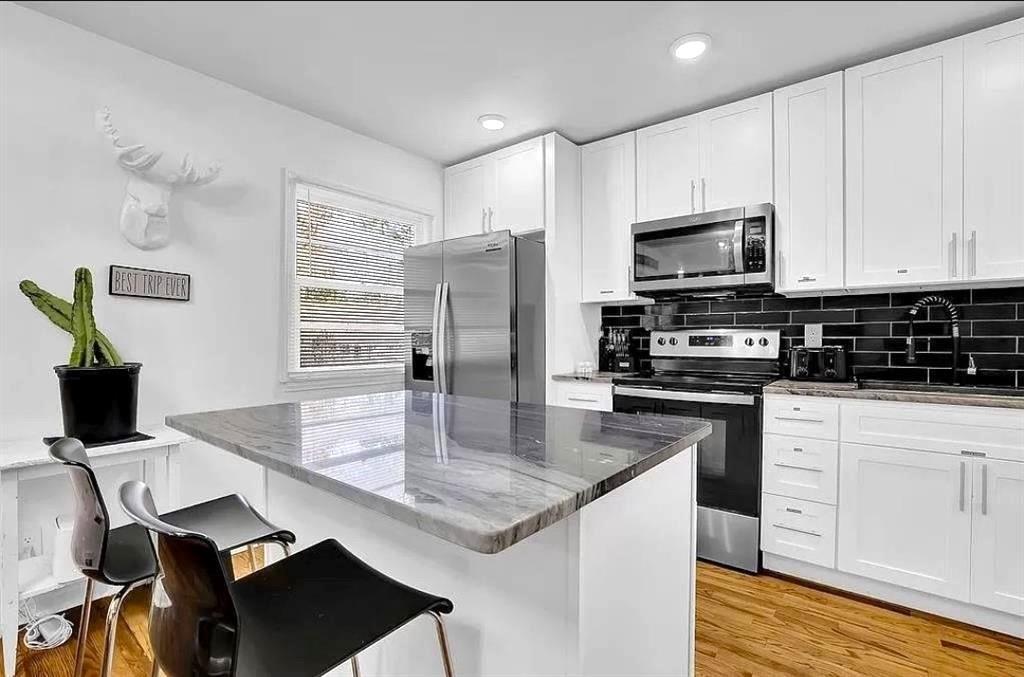 1124 Longshore Drive Decatur, GA 30032 - Photo 7 of 18 a kitchen with kitchen island granite countertop a stove top oven a sink a counter space and cabinets