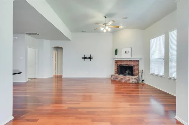 a kitchen with stainless steel appliances granite countertop a stove a sink dishwasher and a fireplace with wooden floor