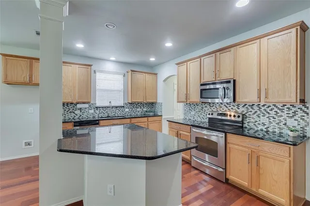 a kitchen with stainless steel appliances granite countertop a sink stove and microwave