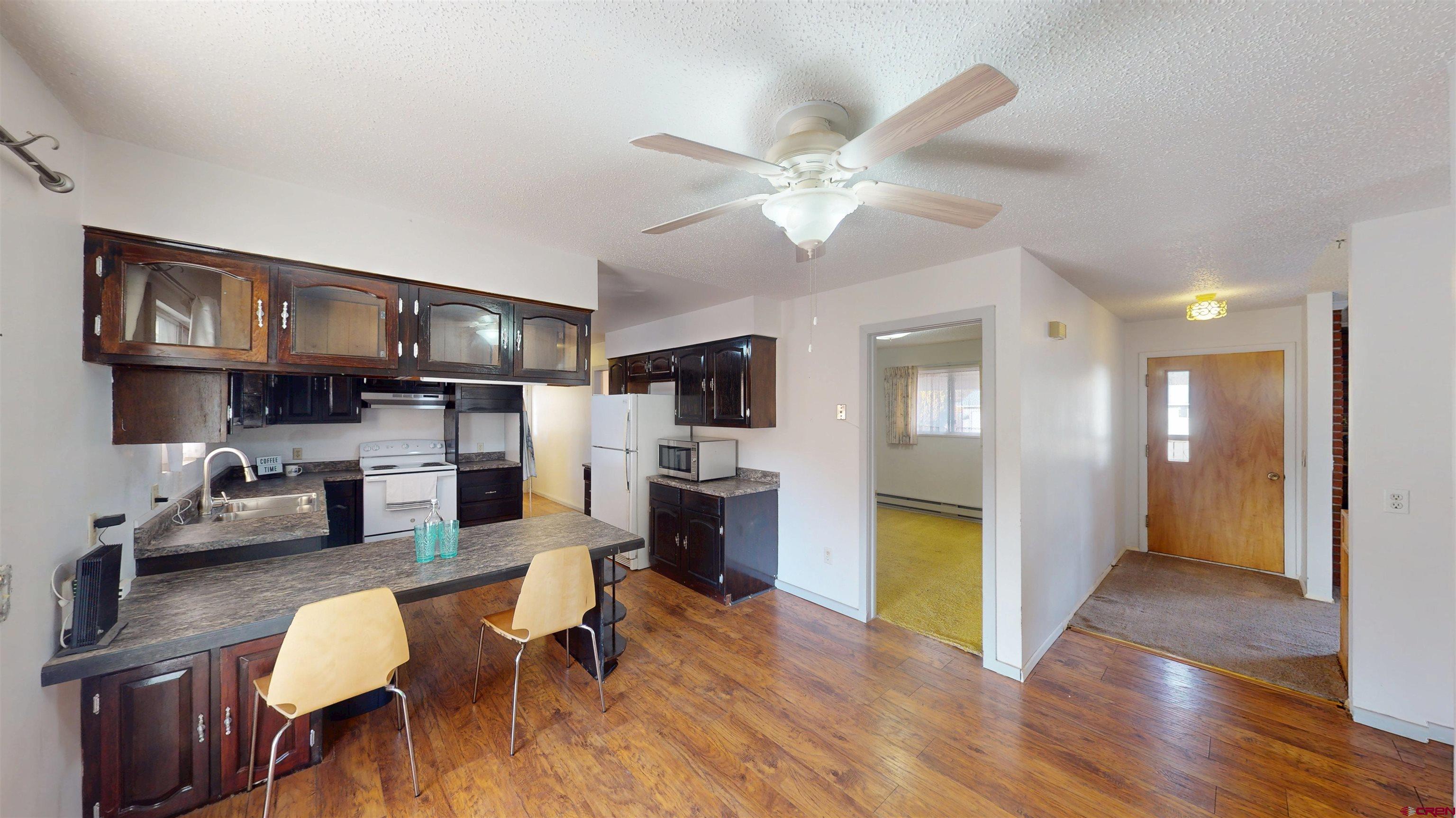 205 Southeast Frontier Avenue Cedaredge, CO 81413 - Photo 11 of 41 a living room with stainless steel appliances kitchen island granite countertop furniture a rug kitchen view and a chandelier