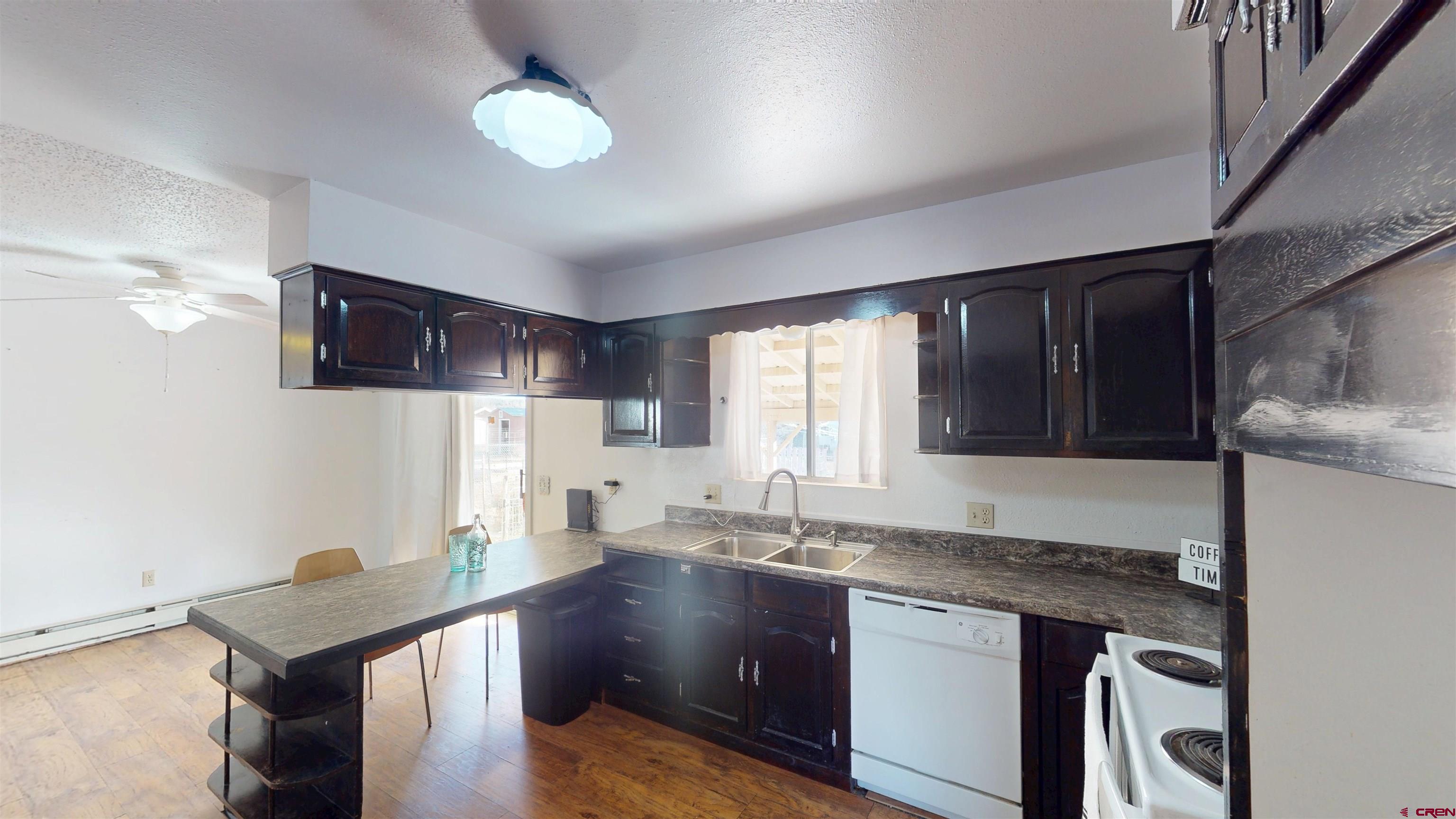 205 Southeast Frontier Avenue Cedaredge, CO 81413 - Photo 15 of 41 a kitchen with granite countertop cabinets a sink a window and stainless steel appliances