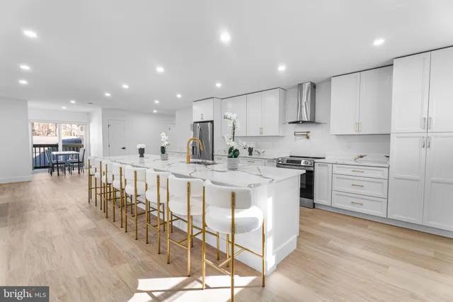 a kitchen with stainless steel appliances kitchen island wooden cabinets and white cabinets