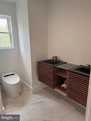 a bathroom with a toilet a sink and mirror