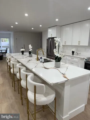 a kitchen with a dining table chairs and white cabinets