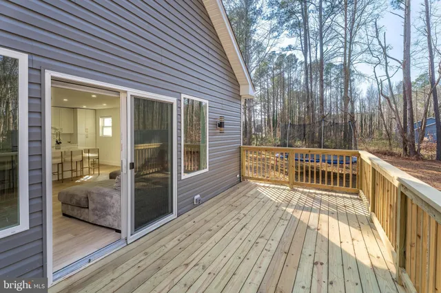 a view of a hallway with wooden floor and a bathroom