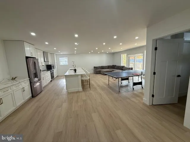 a view of a kitchen with refrigerator microwave and wooden floor