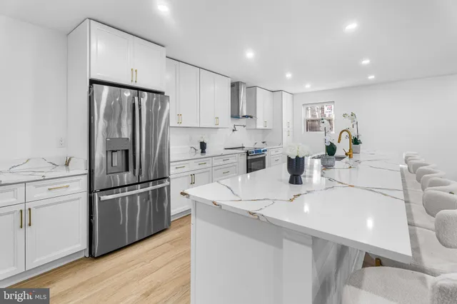a large kitchen with stainless steel appliances lots of counter space and a sink