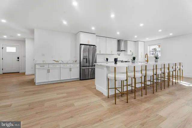 a kitchen with stainless steel appliances white cabinets and a stove top oven