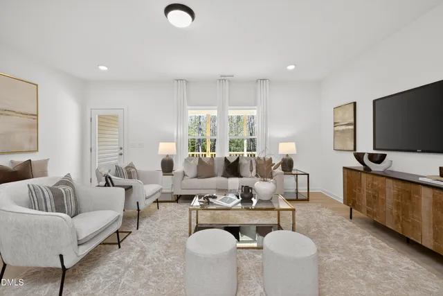 a living room with furniture flat screen tv and window