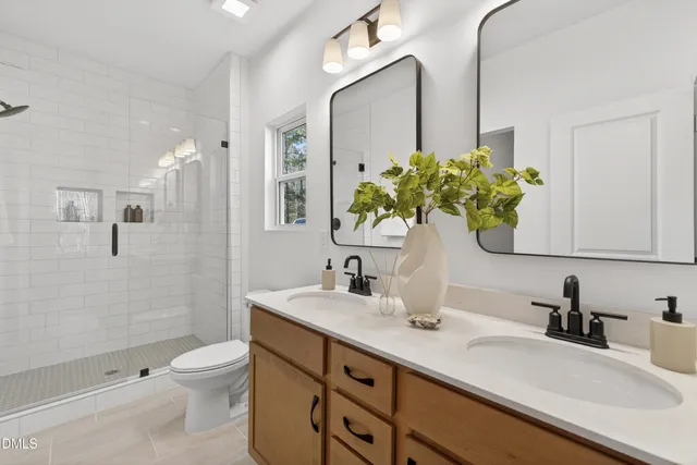 a bathroom with a double vanity sink toilet and shower
