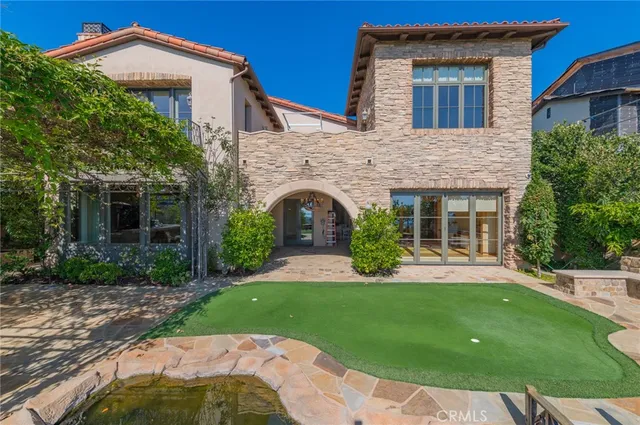 a view of a backyard with lawn chairs potted plants and a big yard