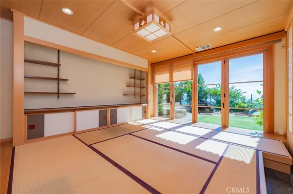 a bedroom with a large bed and large windows