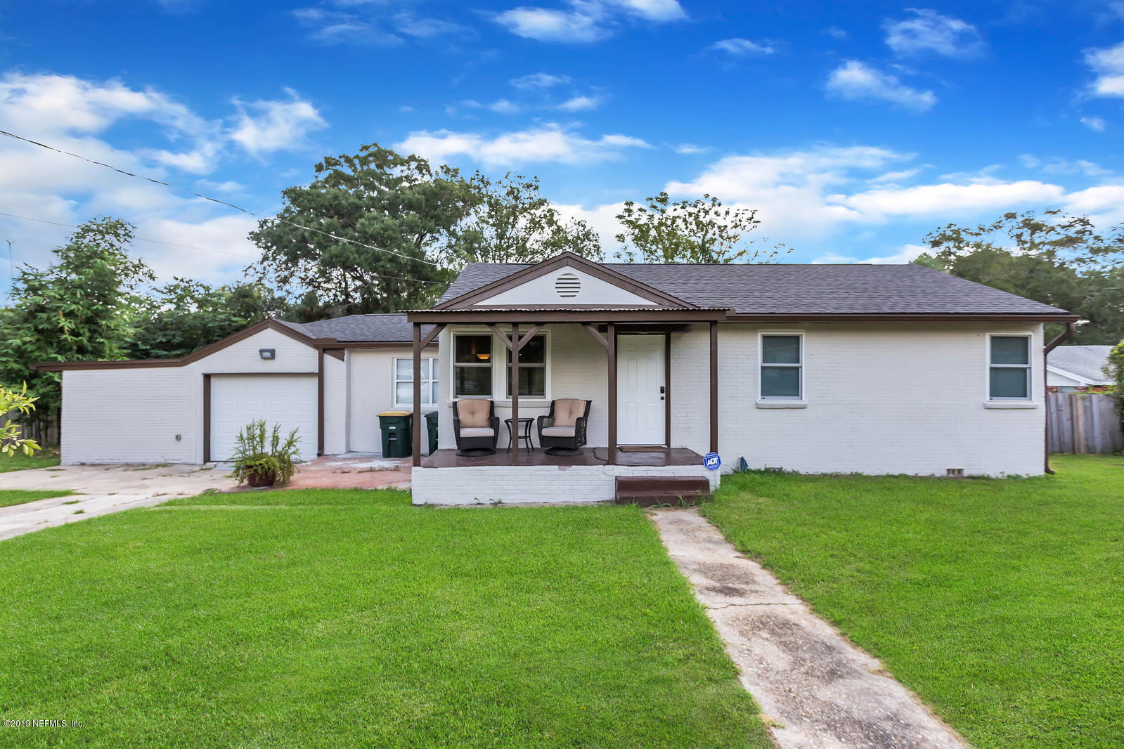 9767 Lily Road Jacksonville, FL 32246 - Photo 1 of 29 a front view of a house with a garden and trees