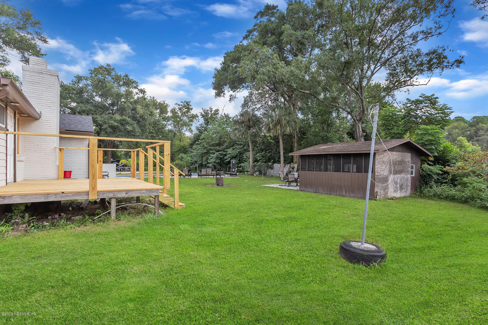 9767 Lily Road Jacksonville, FL 32246 - Photo 18 of 29 a backyard of a house with table and chairs