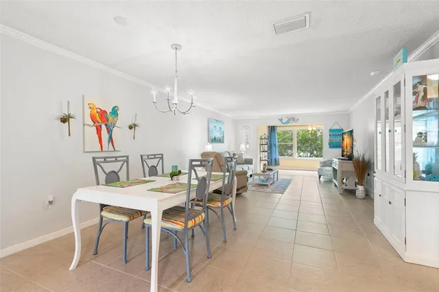 a view of a dining room with furniture a livingroom and chandelier