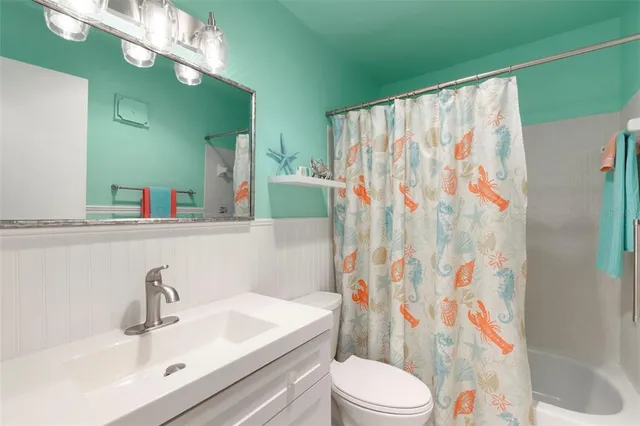 a bathroom with a sink a toilet and shower curtain