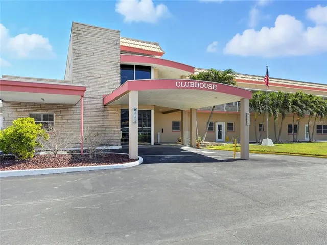 a view of a white building with swimming pool in front of it