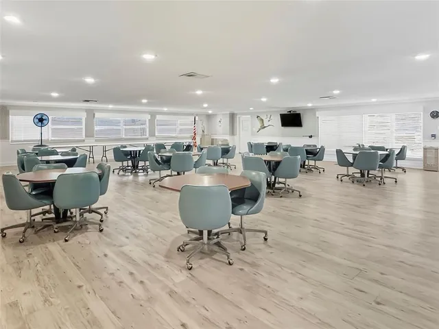 a living room with lots of furniture a rug kitchen view and a chair