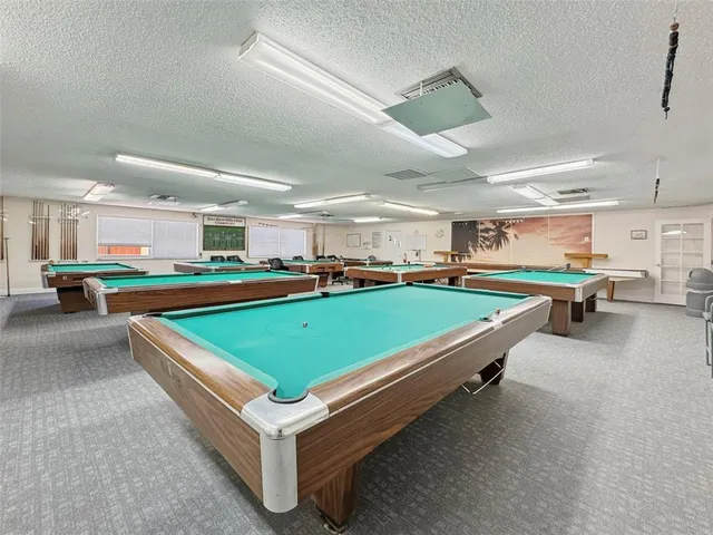 a room with pool table and windows
