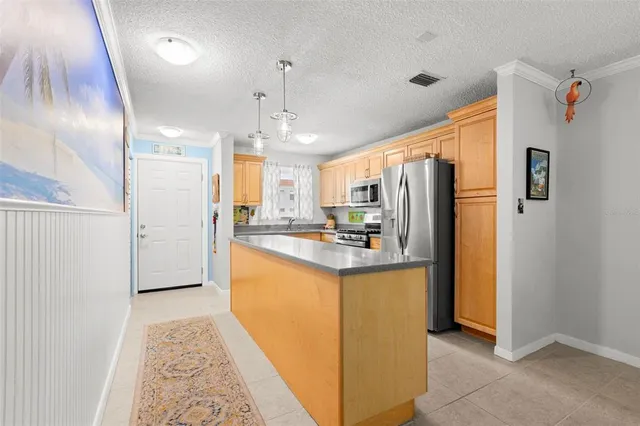a kitchen with stainless steel appliances granite countertop a refrigerator a sink and a stove