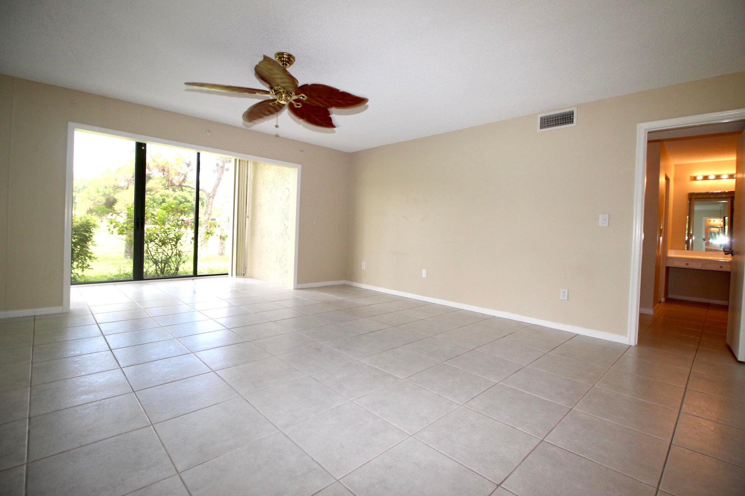 21766 Cypress Drive, Unit 20A Boca Raton, FL 33433 - Photo 11 of 21 a view of an empty room with a chandelier fan and a window