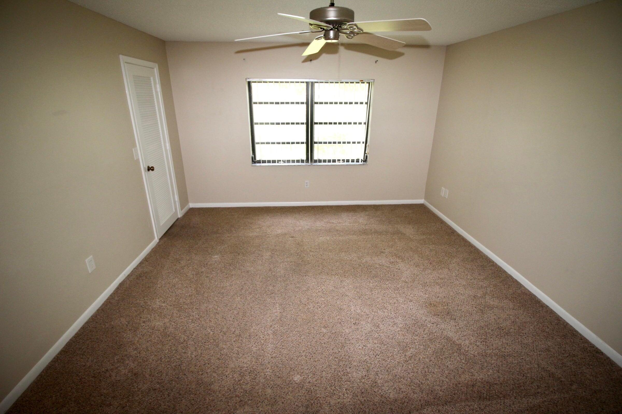 21766 Cypress Drive, Unit 20A Boca Raton, FL 33433 - Photo 9 of 21 an empty room with a window and a chandelier fan