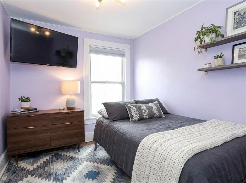 636 Holmdel Road Hazlet, NJ 07730 - Photo 28 of 47 a bedroom with a bed a flat tv screen and a potted plant