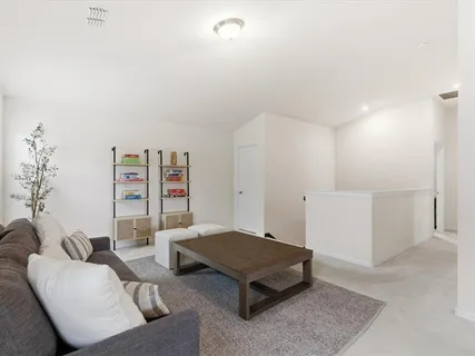 a living room with furniture and book shelf