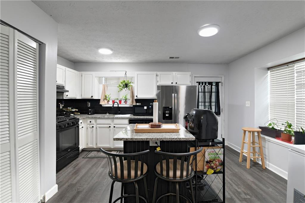 2303 Wingfoot Place Decatur, GA 30035 - Photo 4 of 10 a kitchen with a dining table chairs refrigerator and cabinets
