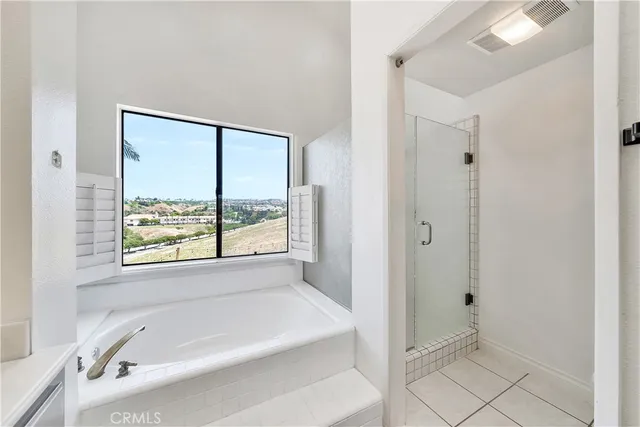 a bathroom with a tub a sink and a window