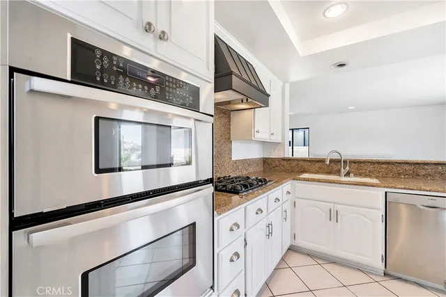 a kitchen with granite countertop white cabinets and white appliances