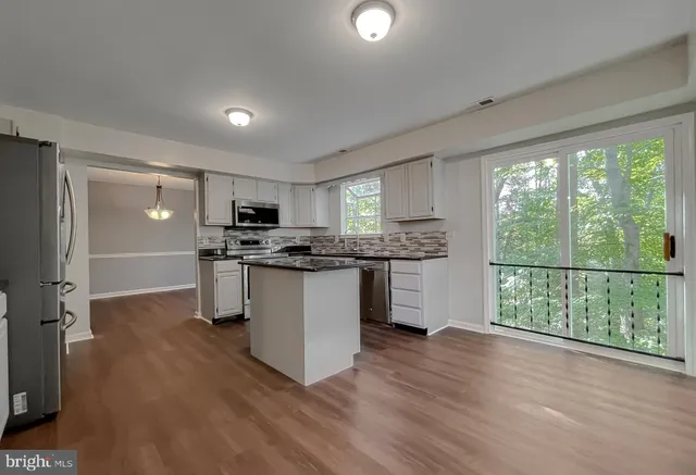 a kitchen with a table chairs a stove a sink dishwasher with a dining table and chairs