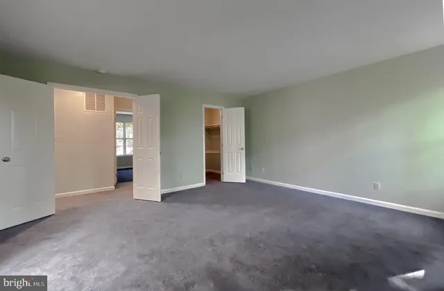 an empty room with windows and closet