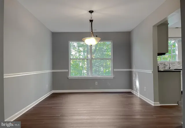 a dining room with furniture a chandelier and wooden floor