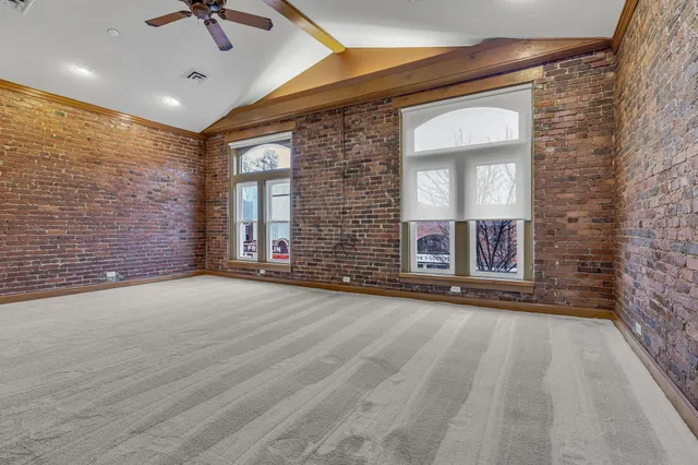 a view of an empty room with a fireplace and a window