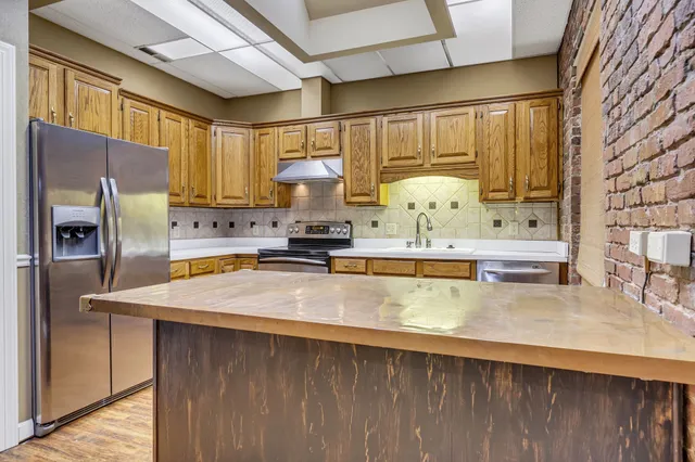 a kitchen with stainless steel appliances a sink a stove and a refrigerator