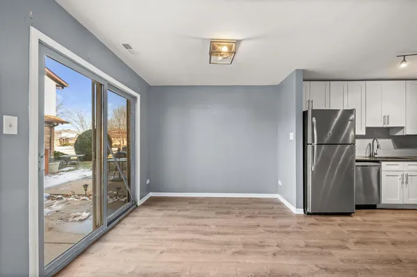 a view of a kitchen with a refrigerator wooden floor and a refrigerator