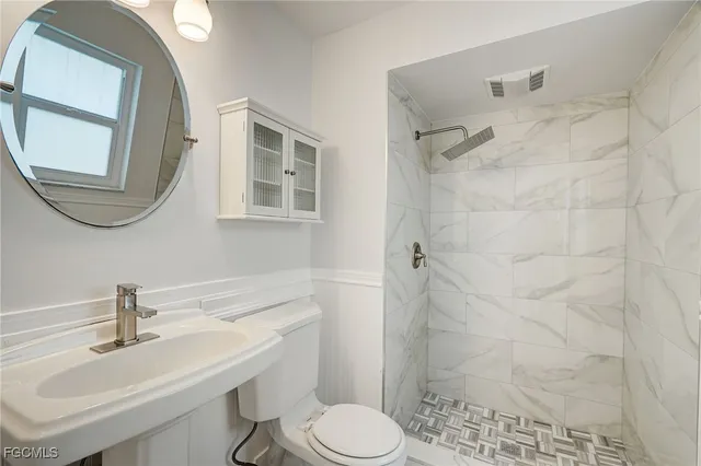 a bathroom with a sink mirror and tub