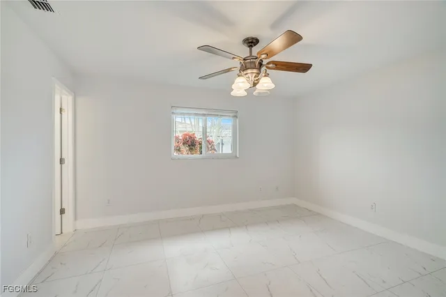 an empty room with a window and a fan