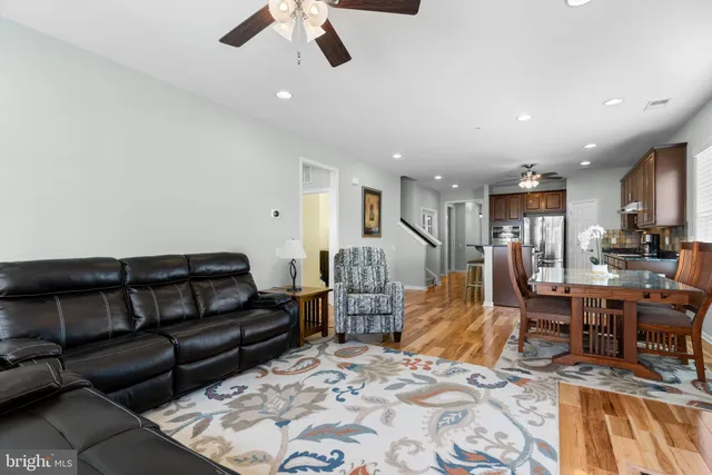 a living room with furniture and a dining table with kitchen view