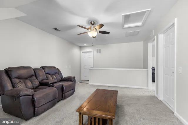 a living room with furniture and a ceiling fan