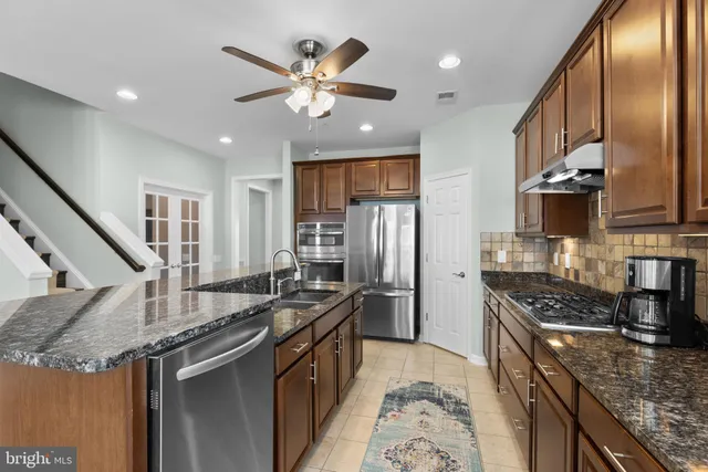a kitchen with stainless steel appliances granite countertop a sink stove and refrigerator