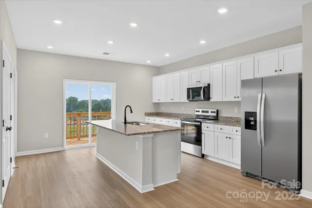 a kitchen with a sink white cabinets and stainless steel appliances