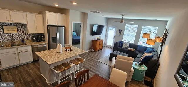a view of kitchen with sink refrigerator dining table and chairs