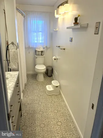 a bathroom with a granite countertop sink a toilet and a shower