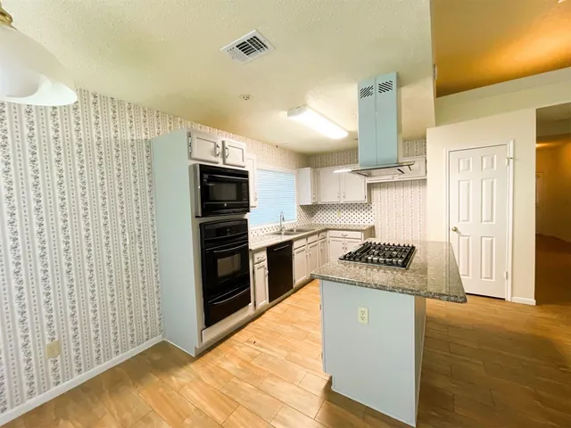 a kitchen with stainless steel appliances granite countertop a stove a sink and a refrigerator