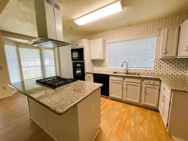 a kitchen with stainless steel appliances granite countertop a stove a sink dishwasher and a refrigerator