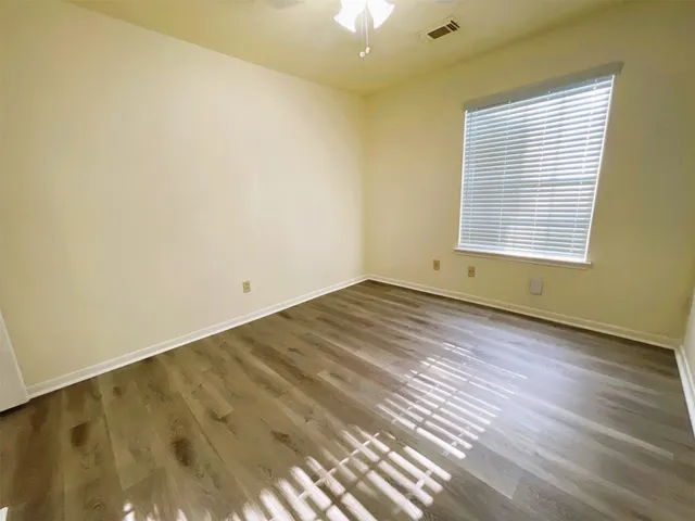 a view of a room with wooden floor and fan