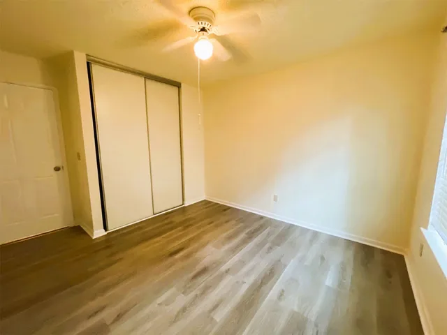 a view of empty room with wooden floor